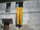 Uno striscione appeso alle finestre della casa occupata dal Mezza Canaja